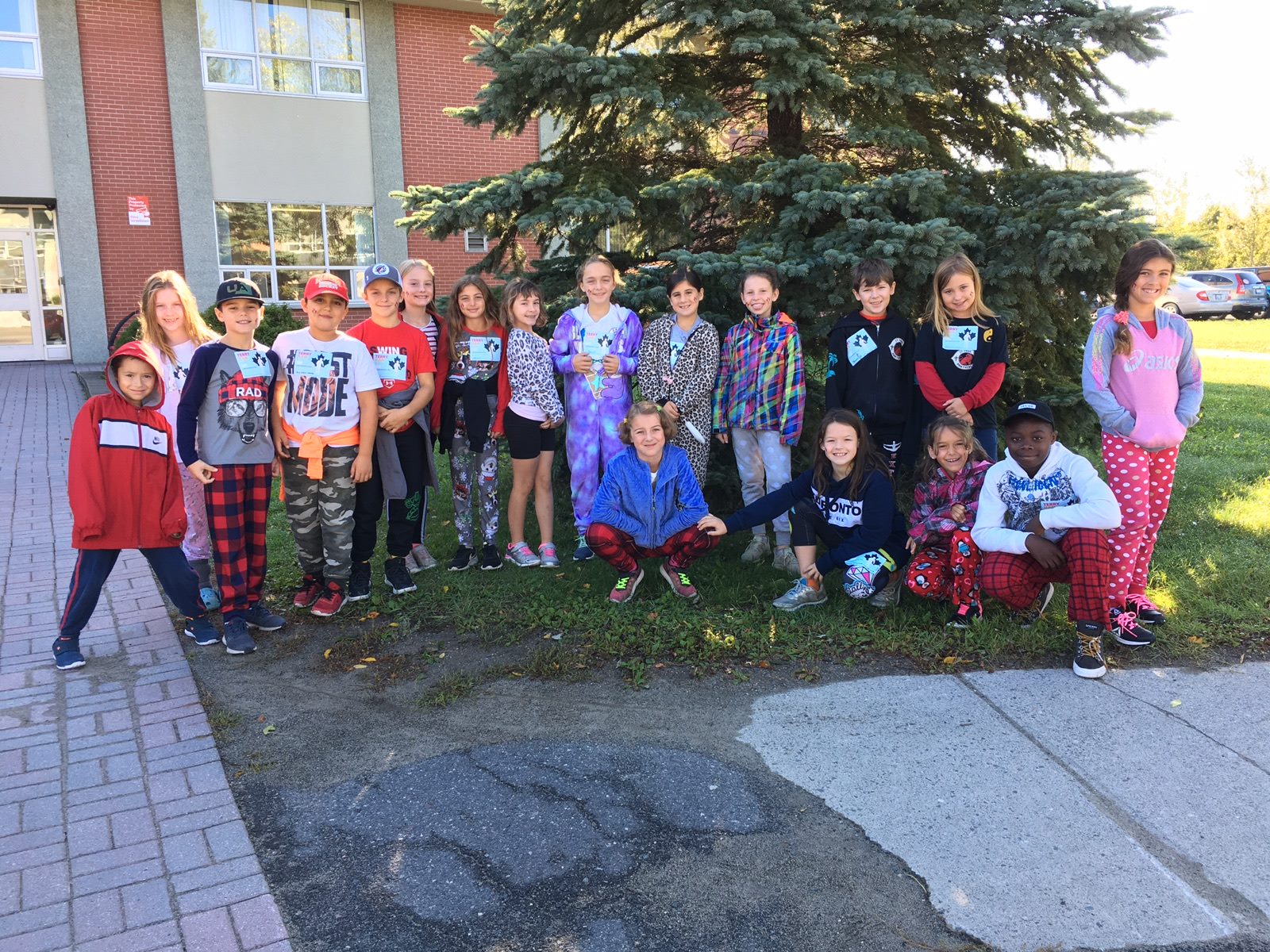 A group of students stand outside ready for their walk.